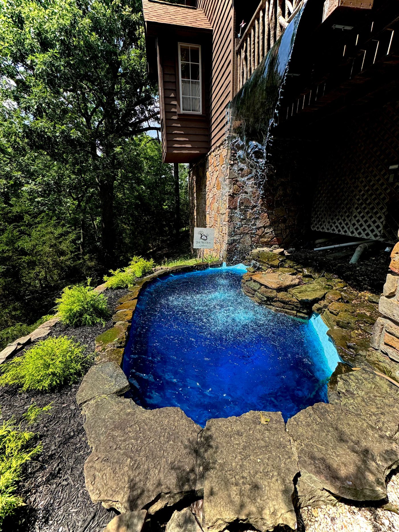 Restored pool with clear blue water and a flowing rock waterfall